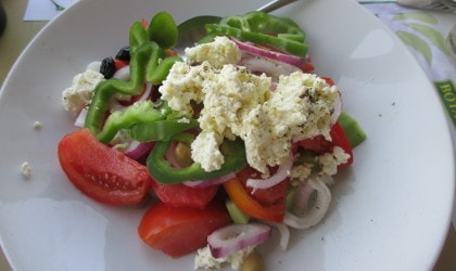 Greek salad with soft white mizithra cheese on top of the vegetables