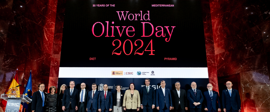 speakers and officials standing side by side in a row under a huge World Olive Day 2024 sign