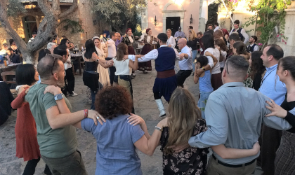 many people dancing together in a village square-like setting at Agreco Farms