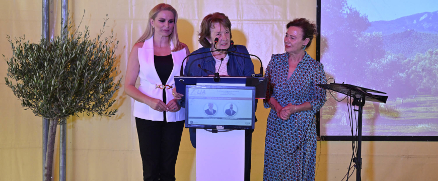 three women by a podium: the moderator, Dr. Antonia Trichopoulou, and Fotini Tirpintiri