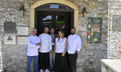 5 chefs standing in front of the arched doorway of a stone museum building