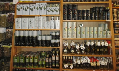Bottles and tins of olive oil on store shelves