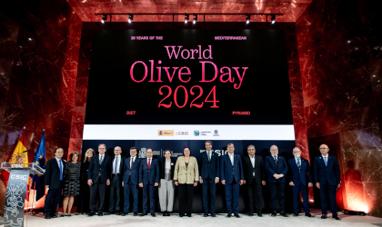 speakers and officials standing side by side in a row under a huge World Olive Day 2024 sign