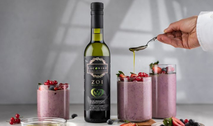 A bottle of ZOI extra virgin olive oil near glasses of pink smoothies