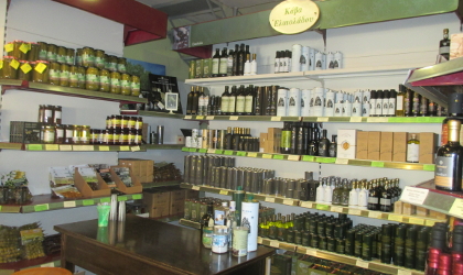 olive oils and other products on the shelves of a specialty store in Athens, with a small table for sampling products in front of the shelves